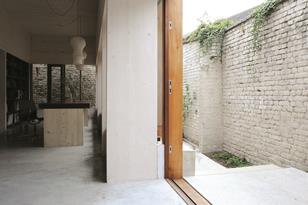 The narrow slots between the building and the perimeter wall read as extensions of the interior.